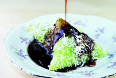 Kuih Lopes, a traditional Malay dessert, is doused with liquid palm sugar